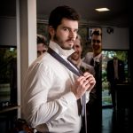 Model van Topsuits doet zijn stropdas om